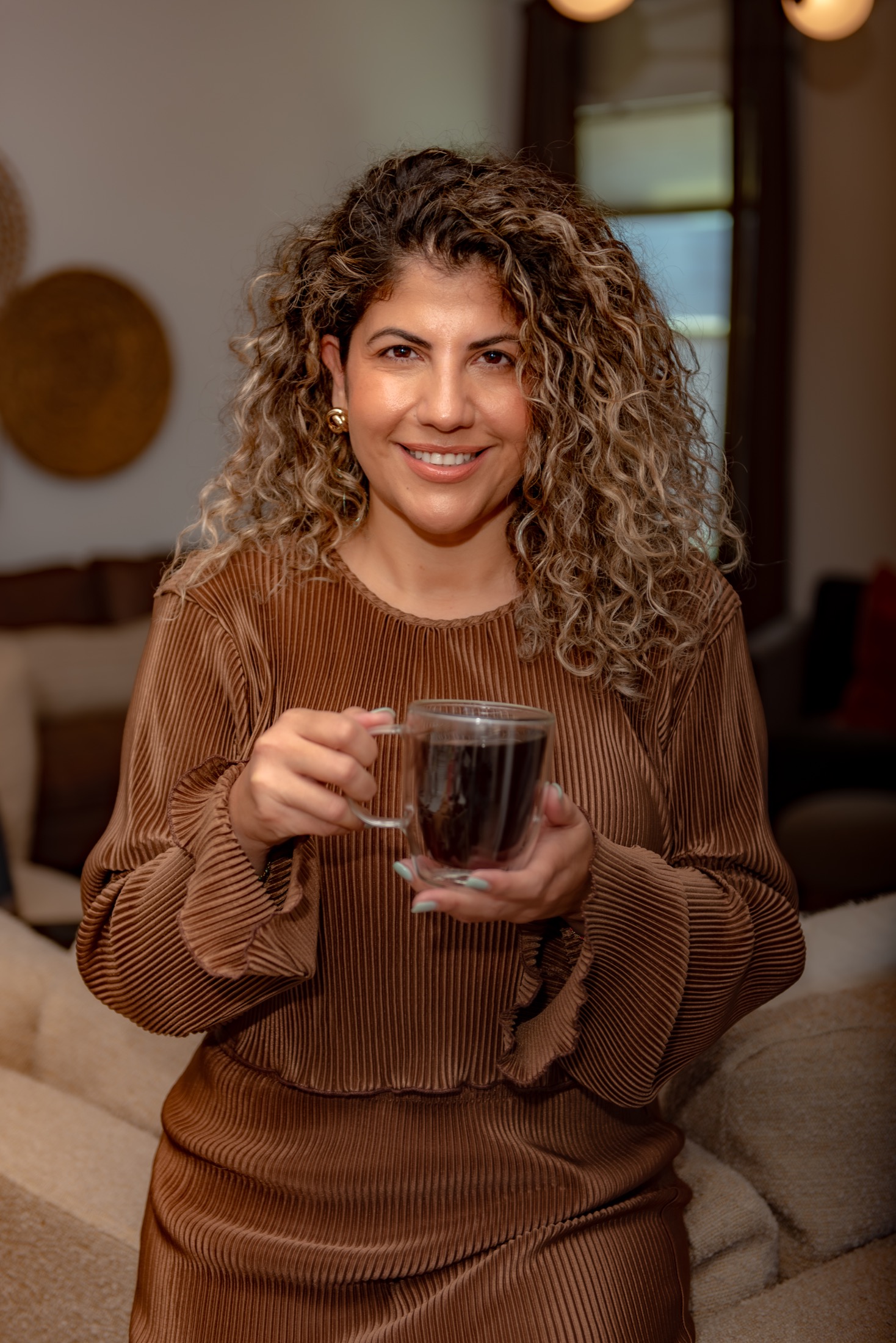 Warm personal brand portrait of a coffee company founder holding a fresh cup