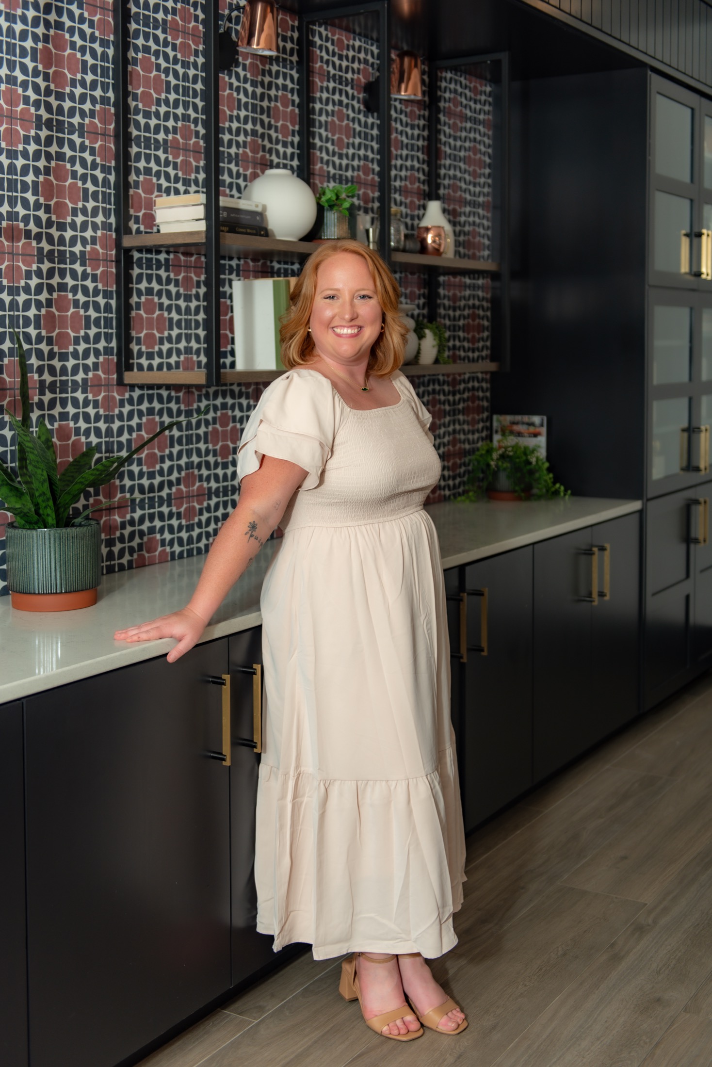 Woman entrepreneur in a cream dress photographed in a modern business setting