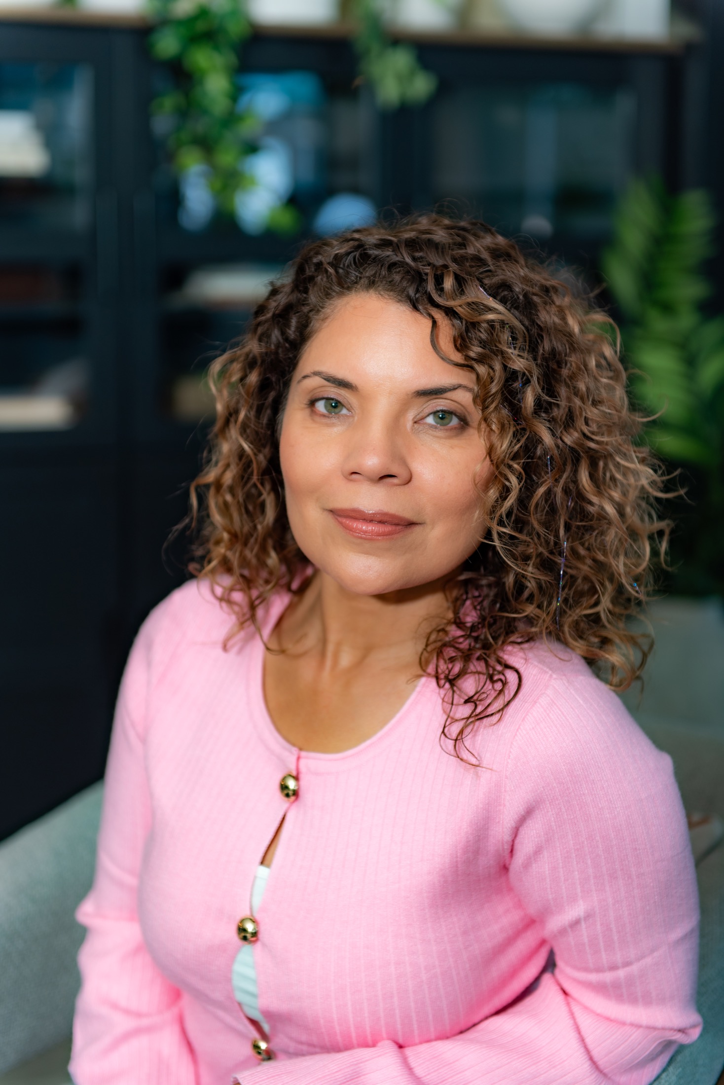 Close personal brand portrait of a woman entrepreneur in a pink cardigan