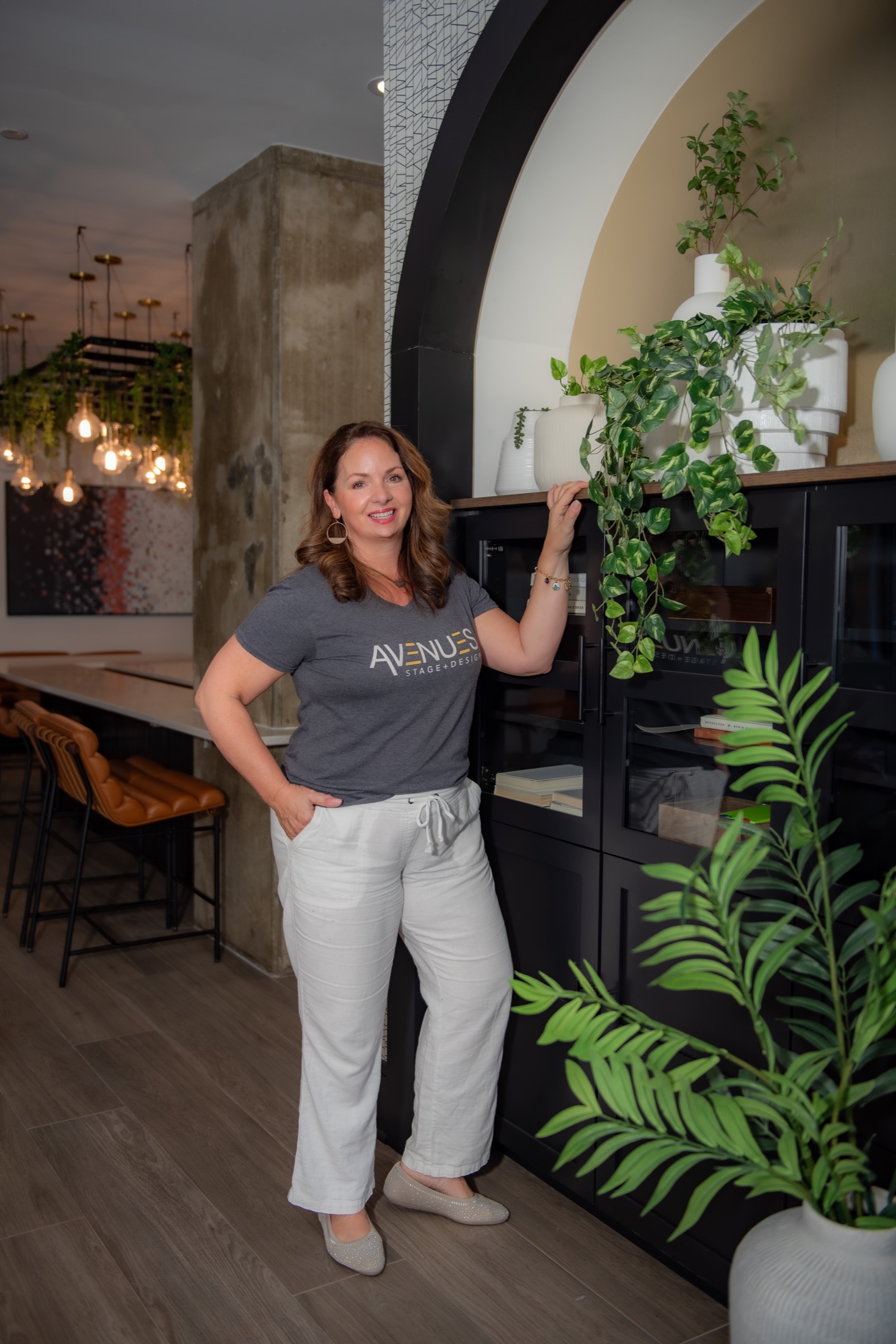 Interior design professional photographed with greenery in a styled workplace