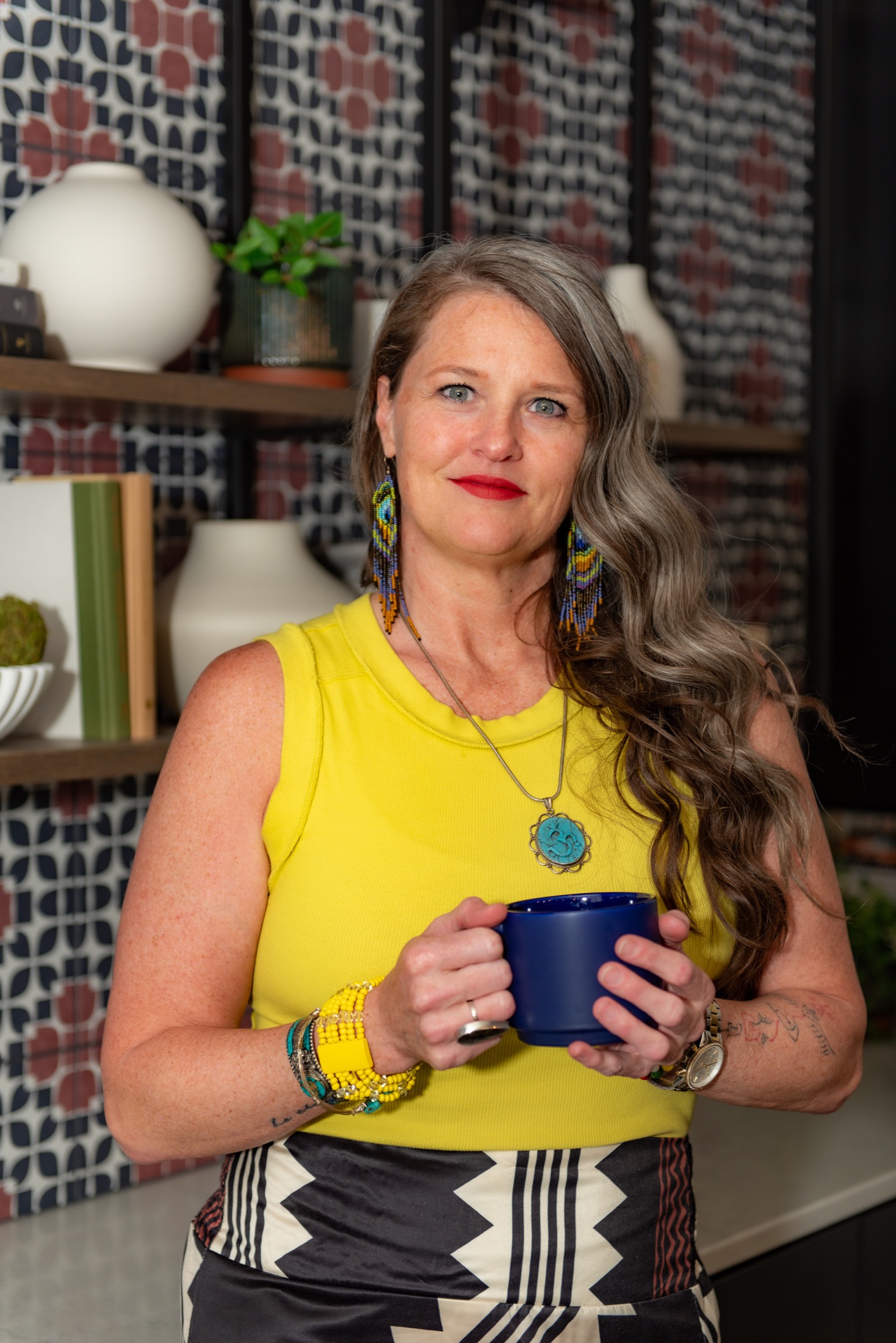 Creative professional in yellow holding a coffee mug during a content-day portrait
