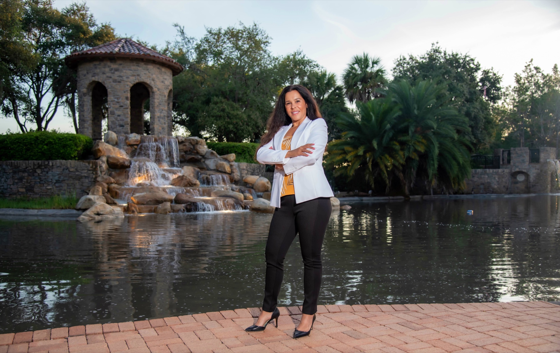 South Florida businesswoman photographed beside a landscaped fountain for her personal brand