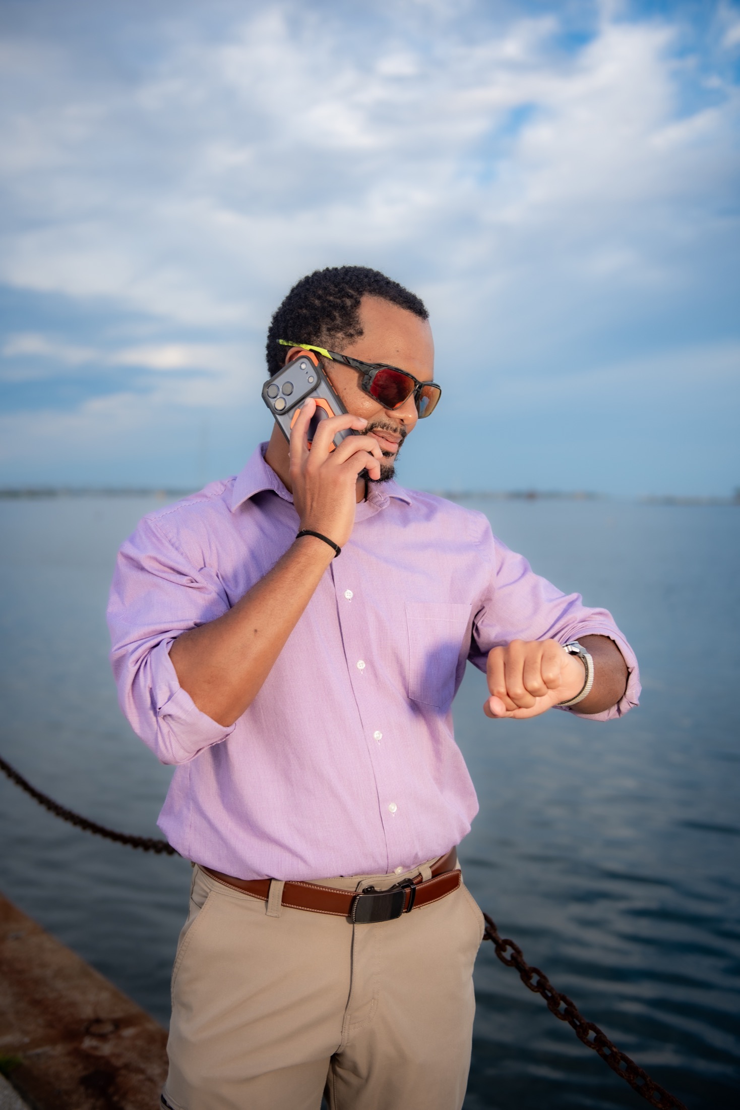 Business professional using his phone during a waterfront brand session