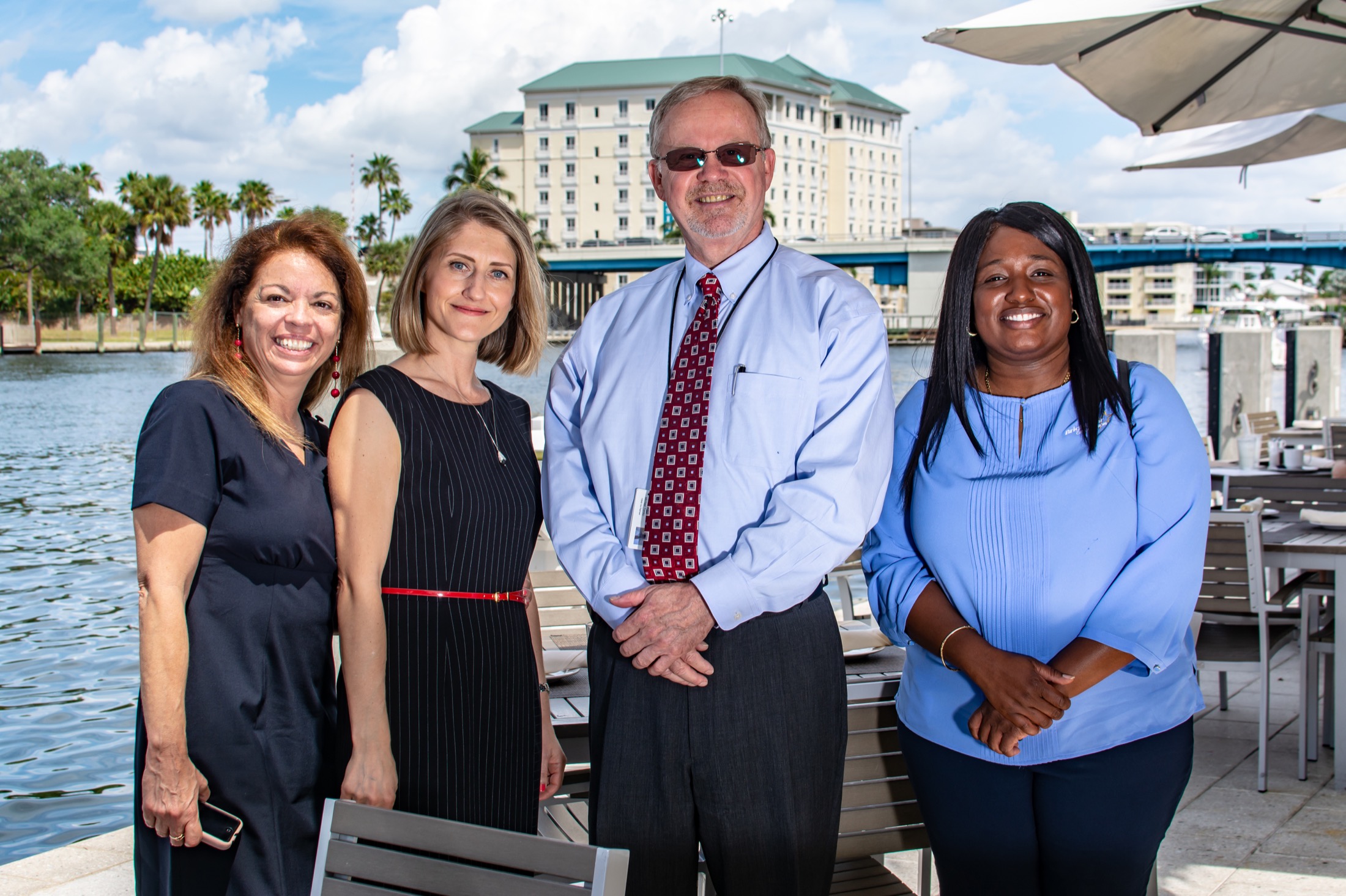Four colleagues posing at a waterfront company event