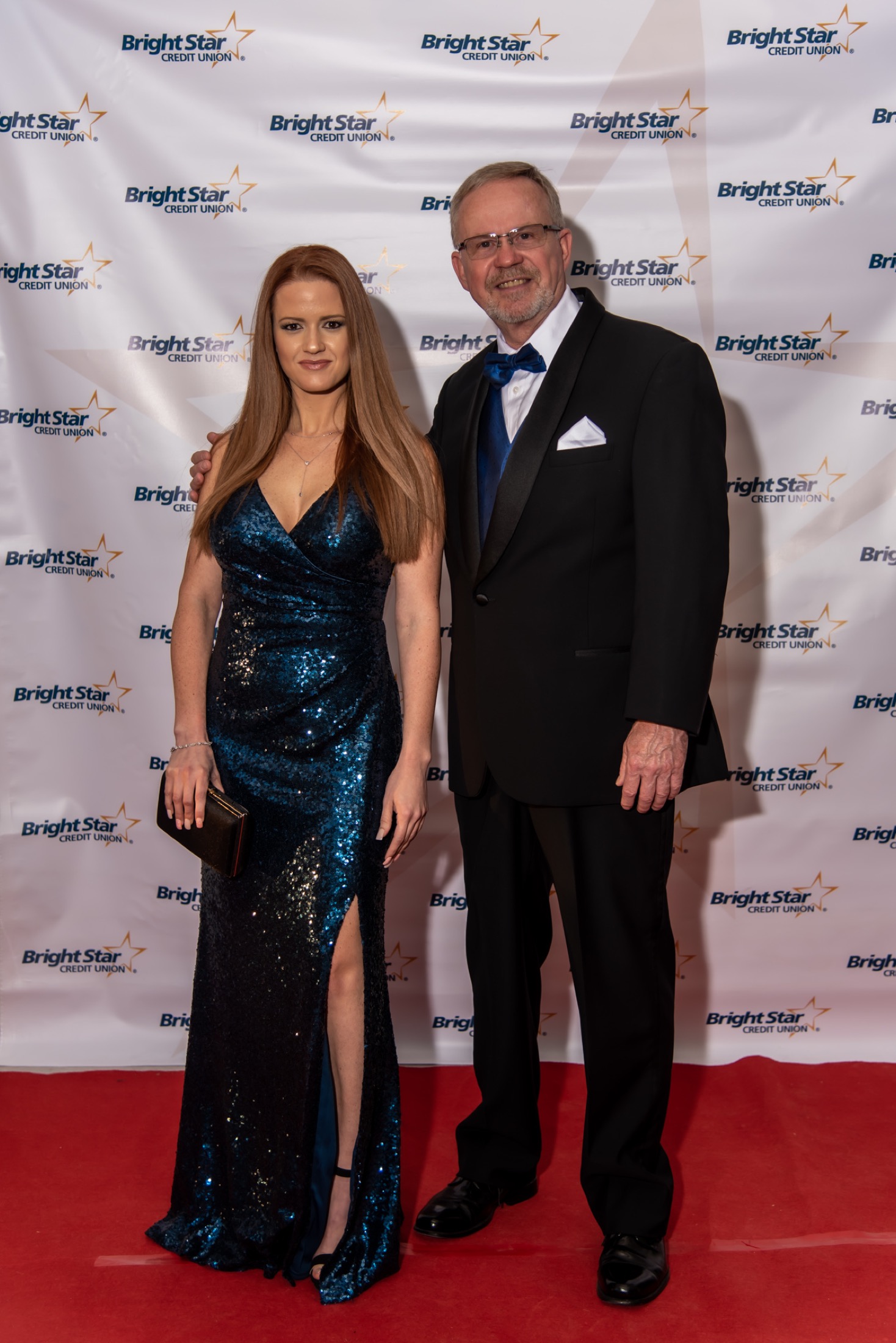 Guests posing on a branded red carpet at a corporate gala