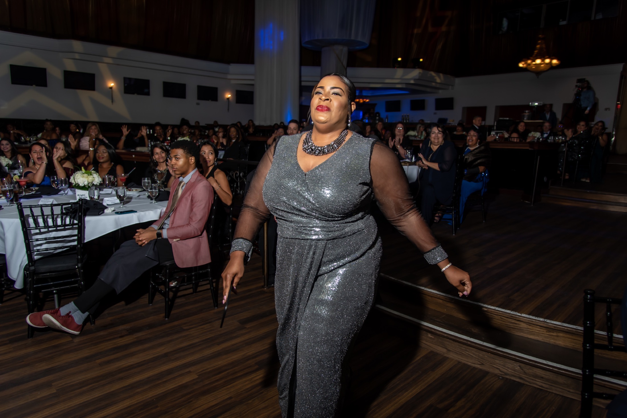 Award recipient walking through a cheering company audience