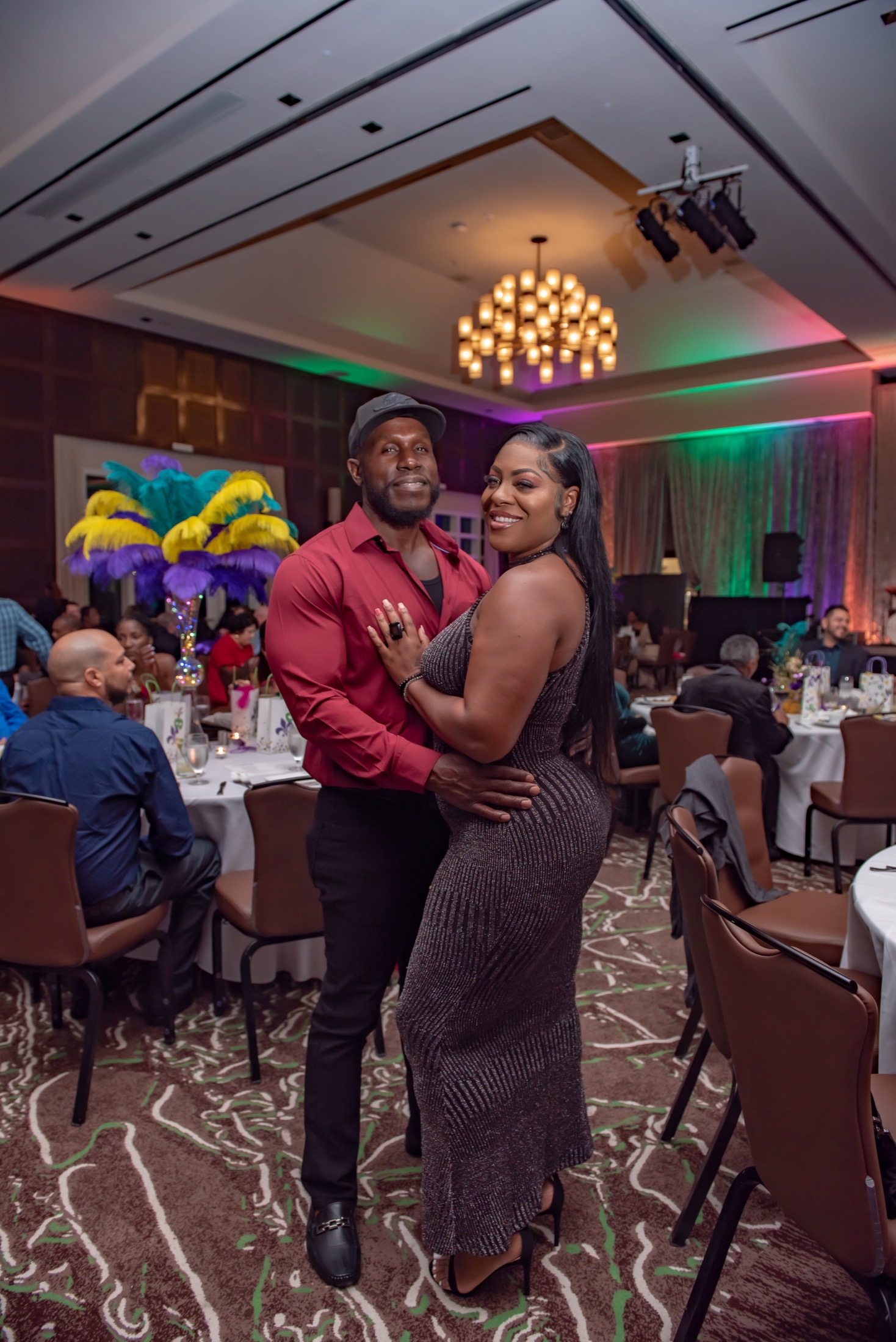Couple posing together inside a colorful corporate gala venue