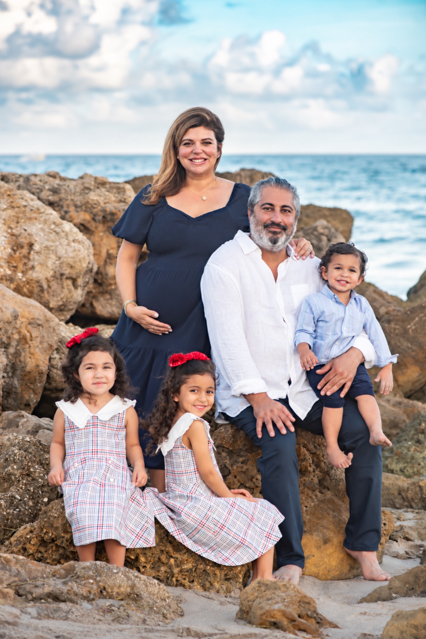 Expectant mother and her family photographed among shoreline rocks