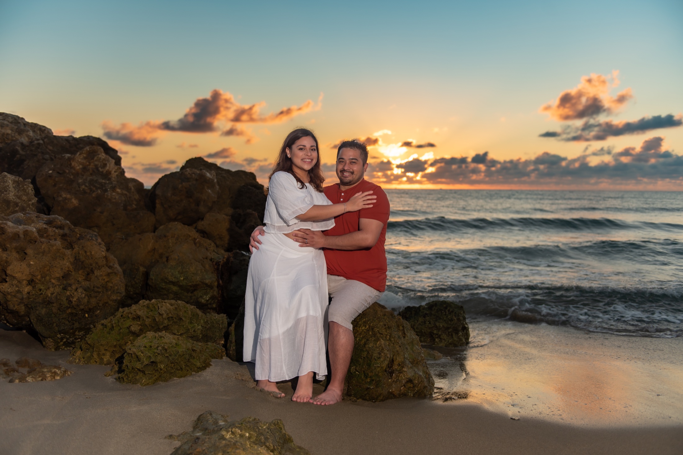 Expectant couple photographed at sunset on a South Florida beach